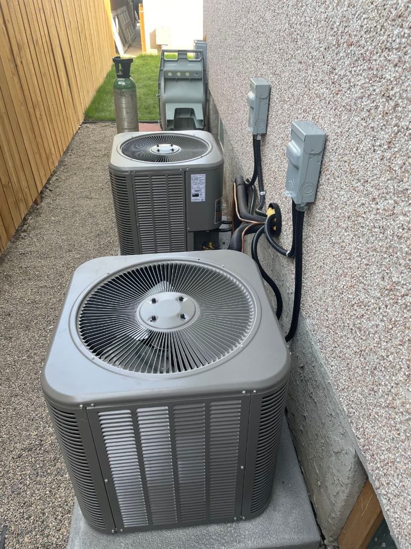 Dual residential AC condenser units with stacked electrical disconnects and refrigerant line routing