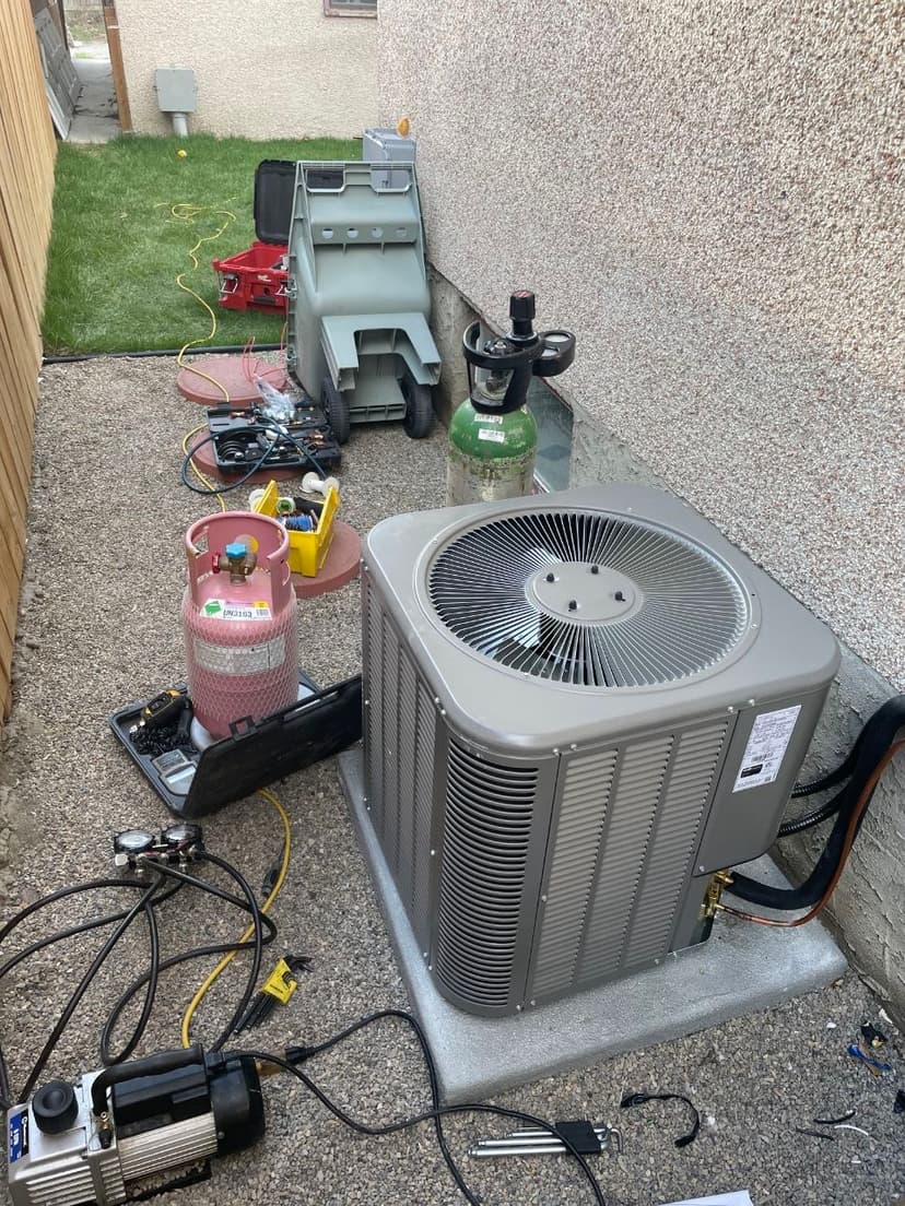 HVAC service equipment including vacuum pump, manifold gauges, and recovery tank during refrigerant recovery